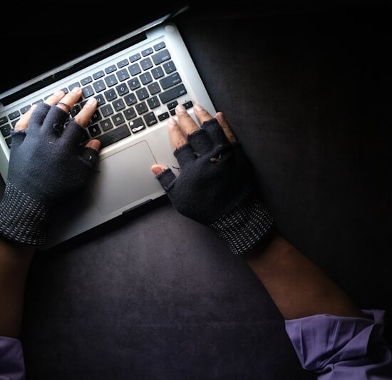 person in black long sleeve shirt using macbook pro