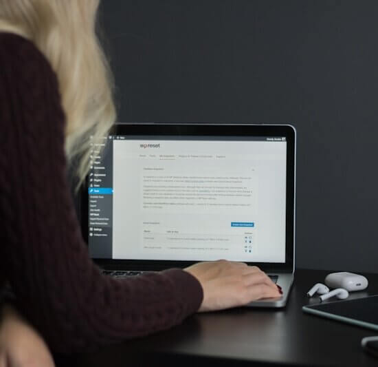 woman in black sweater using macbook pro
