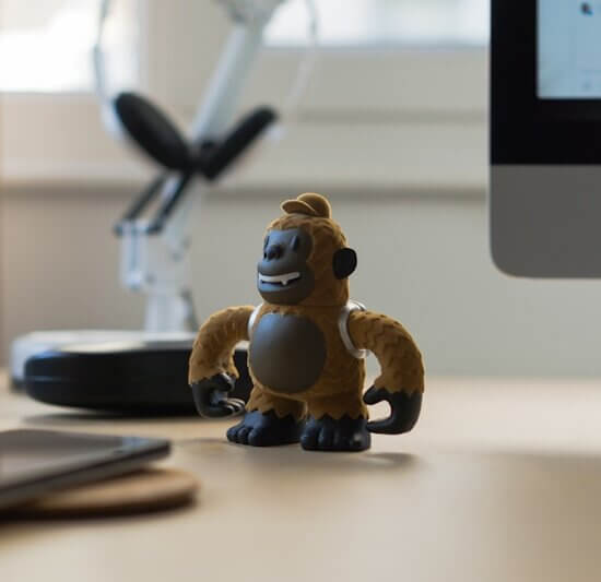 brown monkey toy near black smartphone